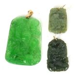 THREE CHINESE YELLOW METAL AND JADE PENDANTS Comprising a rectangular pendant carved in relief