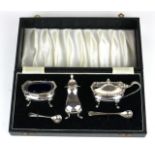 A 20TH CENTURY SILVER THREE PIECE OVAL CONDIMENT SET With shell and scroll border and blue glass