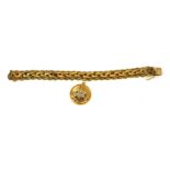 A 14CT GOLD BRACELET HUNG WITH A 14CT GOLD ROUNDEL WITH CENTRAL SAPPHIRE ENCRUSTED SWAN. (19cm,