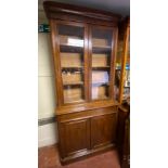 A VICTORIAN MAHOGANY BOOKCASE With deep cushion cornice above two glazed doors enclosing