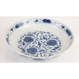 A CHINESE BLUE AND WHITE PORCELAIN 'LOTUS' SHALLOW BOWL Hand painted scrolled floral decoration,