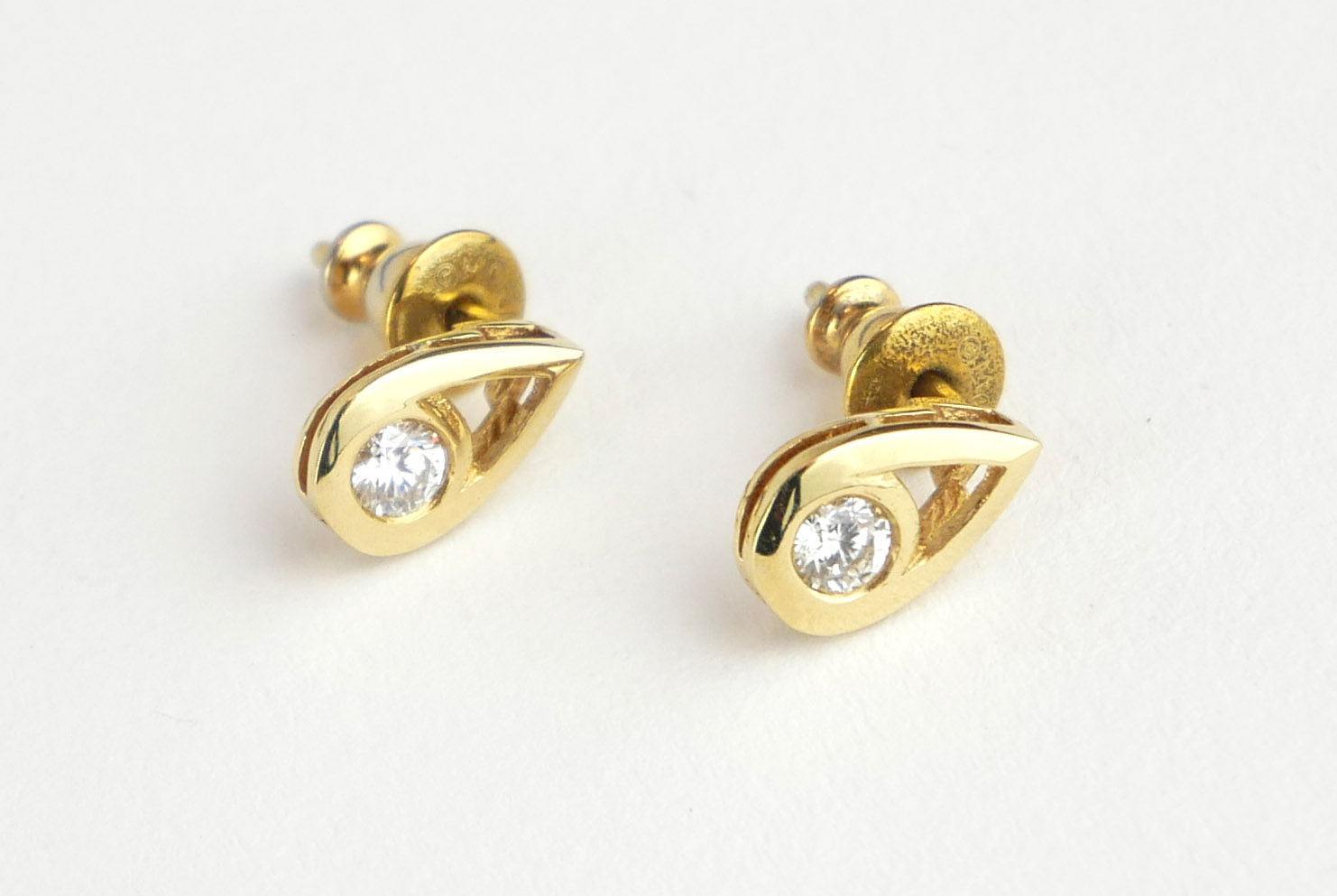 A PAIR OF 18CT GOLD AND DIAMOND STUD EARRINGS The single round cut diamond in a pierced tear form