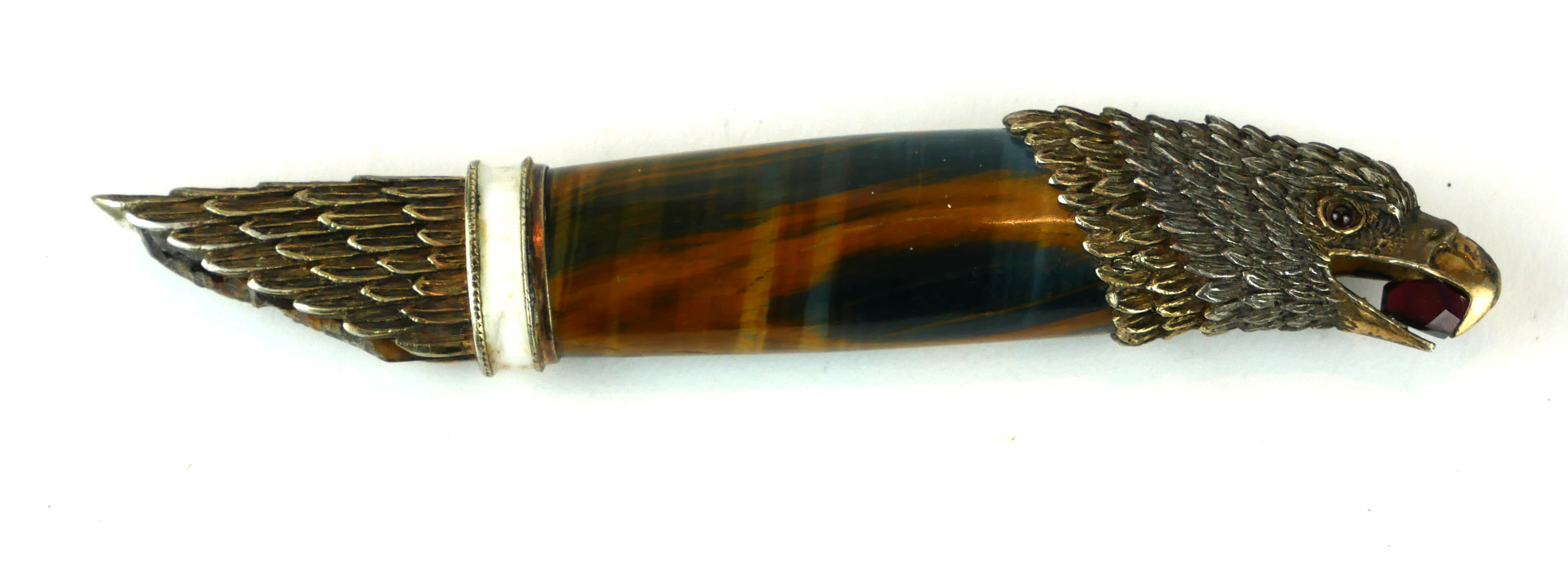 A .925 SILVER GILT AND TIGER'S EYE KNIFE HANDLE FORMED AS AN EAGLE HOLDING A GARNET IN BEAK. (13.