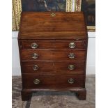 A GEORGIAN SOLID MAHOGANY BUREAU The fall front enclosing a fitted interior above for graduated