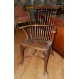 AN 18TH CENTURY ELM COMBE BACK COUNTRY ARMCHAIR With saddle seat, raised on cabriole legs with a pad