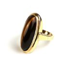 A VINTAGE 9CT GOLD AND TIGERS EYE RING Having an oval cabochon cut stone on plain gold shank (size