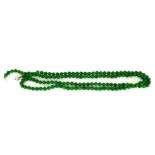 A LONG GREEN JADE NECKLACE With 18ct white gold and diamond clasp. (152cm) Condition: good