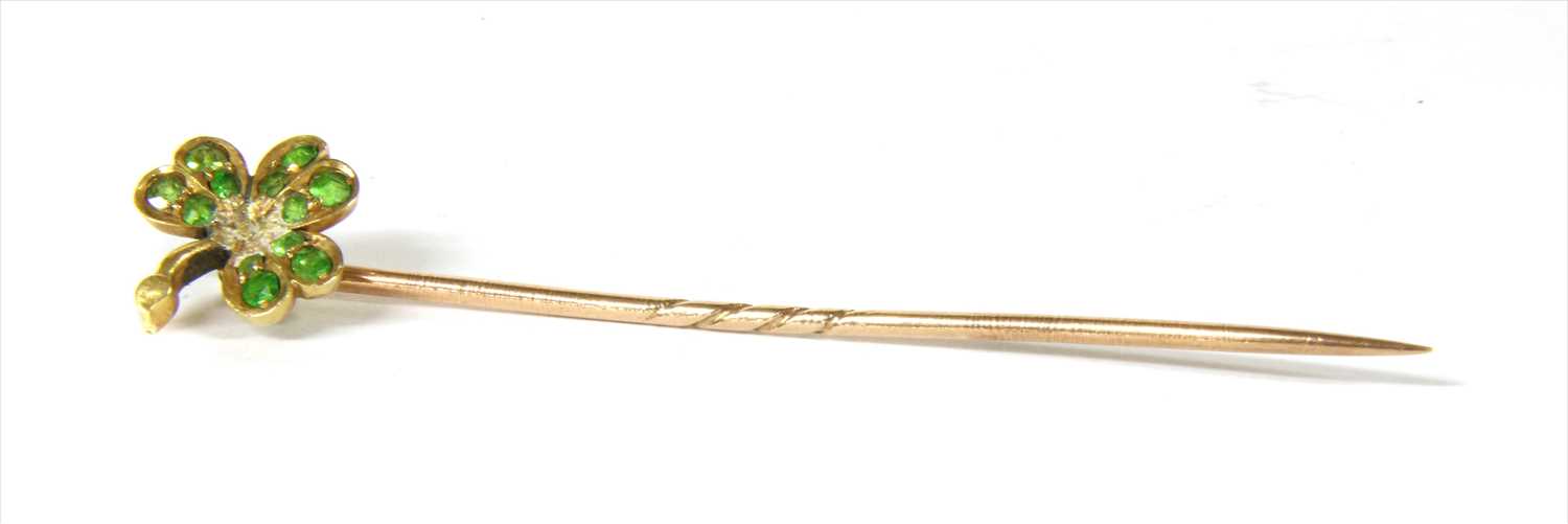 A gold demantoid garnet shamrock stick pin,