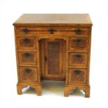 A George III style walnut and oyster veneered knee hole desk,