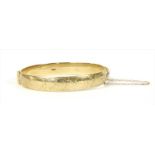 A 9ct gold hinged bangle,