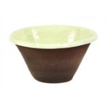 A large green slip glazed terracotta bowl,
