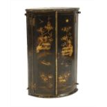 A lacquered bow front hanging corner cupboard,