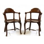 A pair of unusual oak smokers' bow elbow chairs,