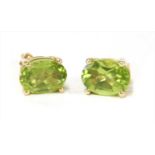 A pair of gold single stone peridot stud earrings,