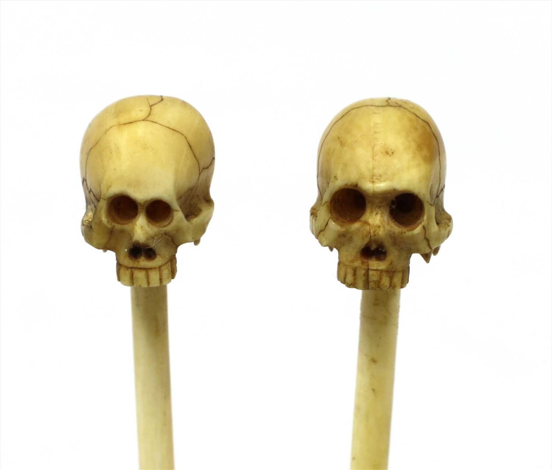 Two miniature memento mori ivory skulls,