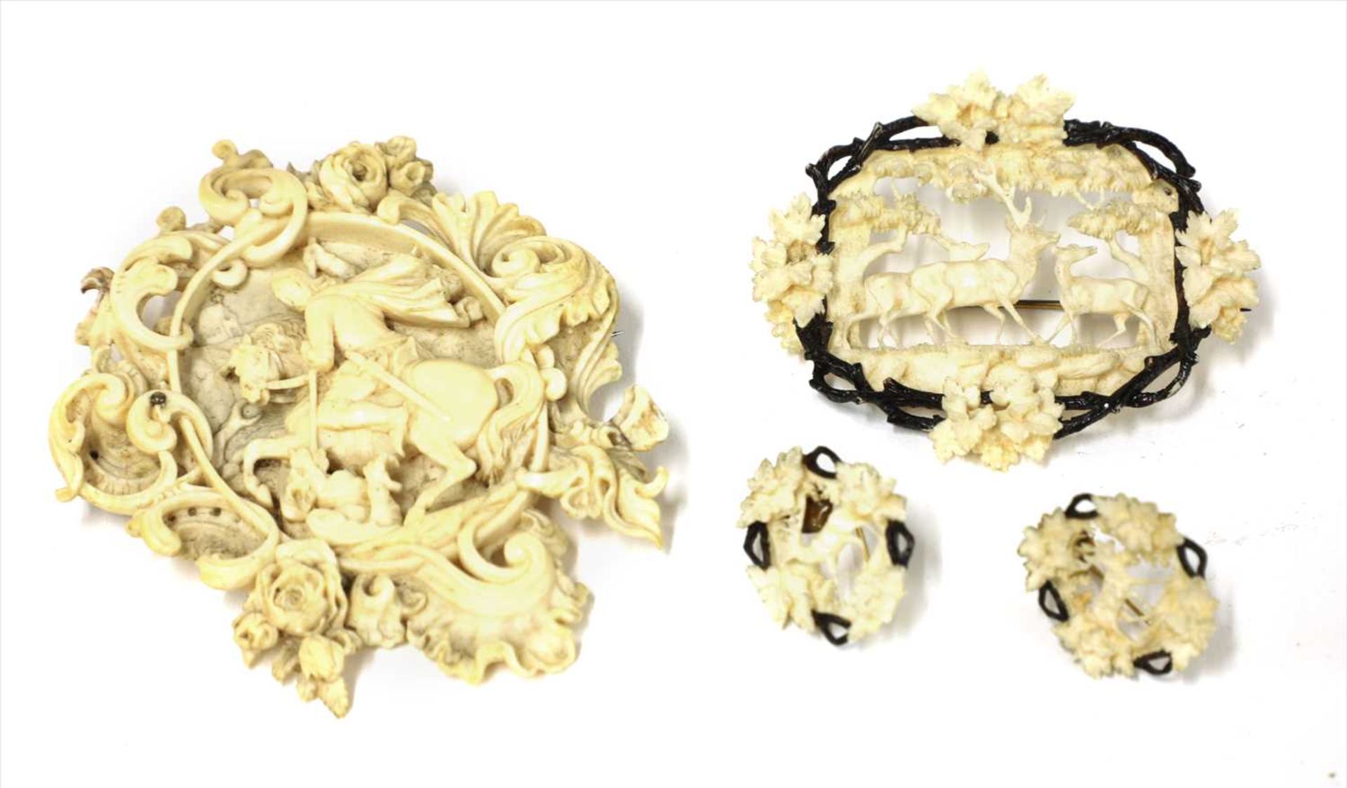 Two carved ivory brooches and a pair of earrings,