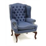 A Georgian style mahogany wing armchair upholstered in blue,