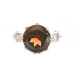 A platinum garnet and diamond ring