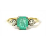 A gold emerald and diamond three stone ring,