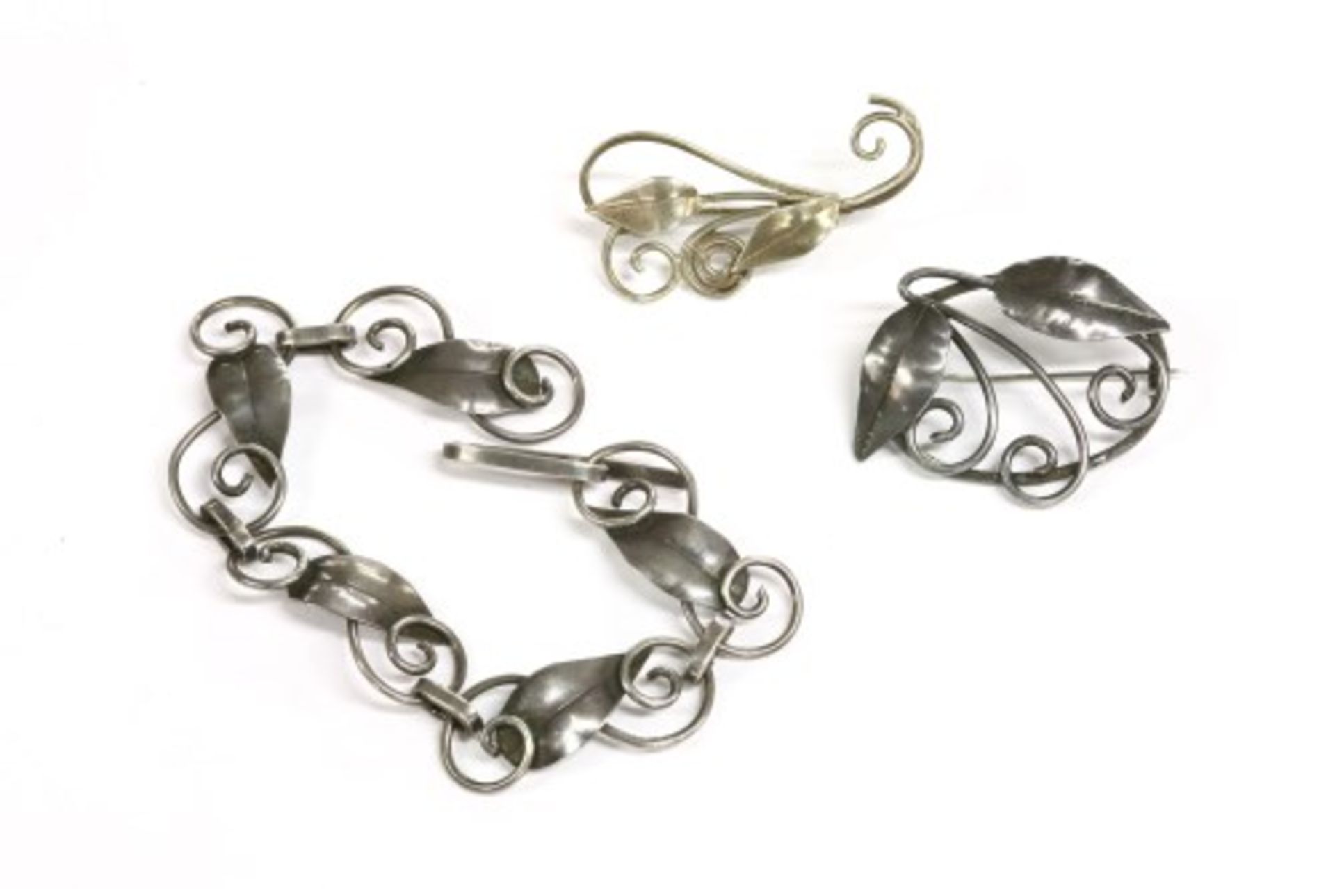 An Arts & Crafts silver bracelet and brooches