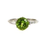 A platinum peridot and diamond three stone ring