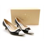A pair of Prada black and white leather court shoes
