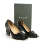 A pair of Gucci black leather peep toe court shoes,