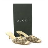 A pair of Gucci monogrammed canvas and cream leather mules,