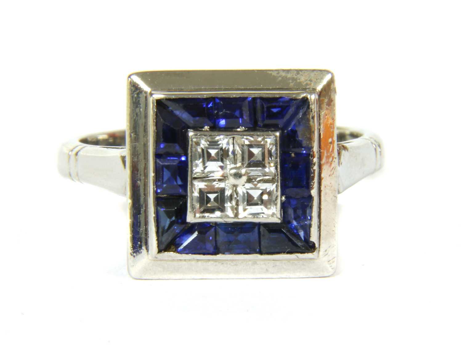 An Art Deco platinum diamond and sapphire square cluster ring,