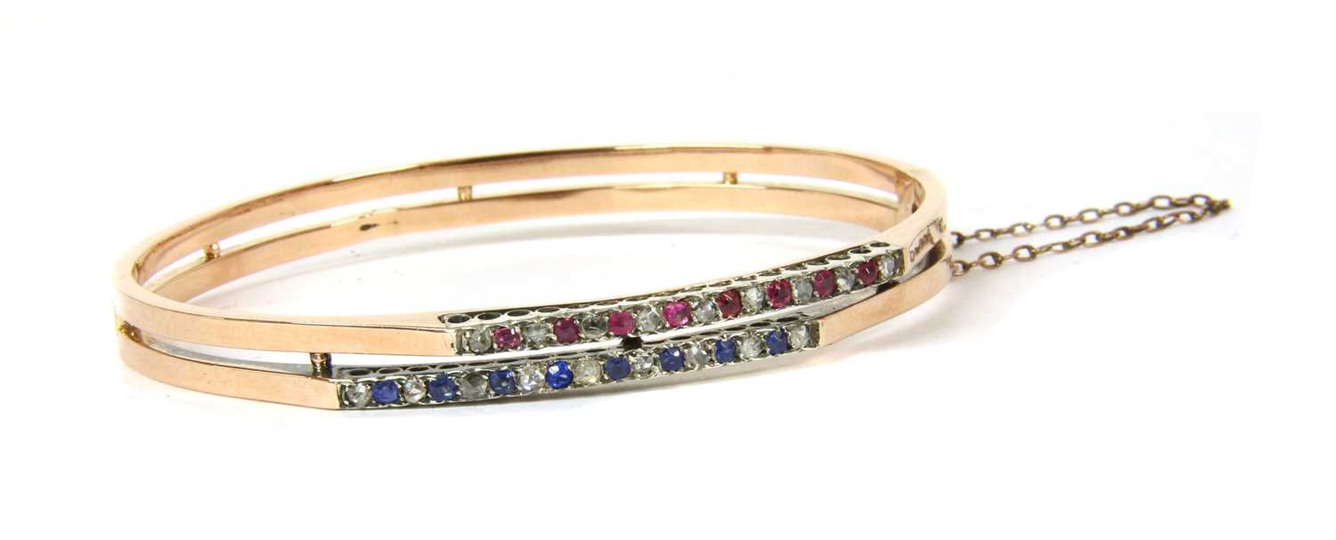 A French 18ct gold diamond, ruby and sapphire bangle, c.1900,