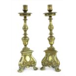 A pair of cast brass candlesticks,