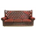 A red leather wingback sofa,