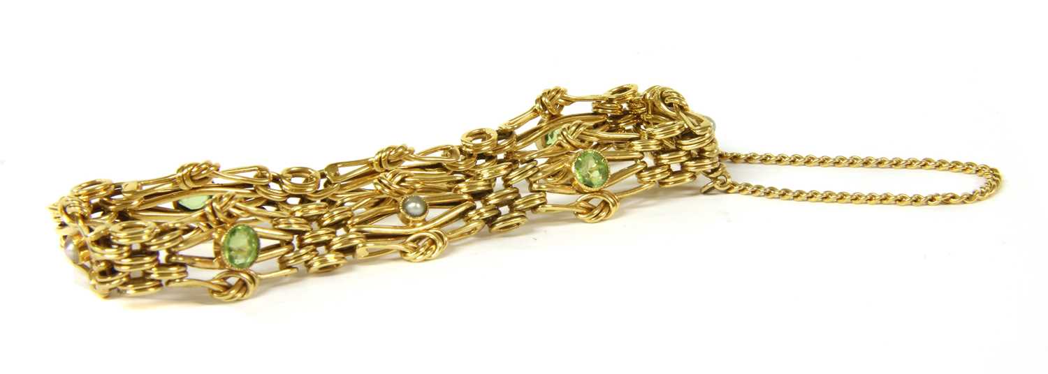 An Edwardian gold peridot and split pearl four row gate bracelet,