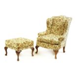 A wing armchair and foot stool,