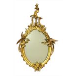 A small carved giltwood framed oval mirror,