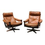 A pair of tan leather reclining armchairs,