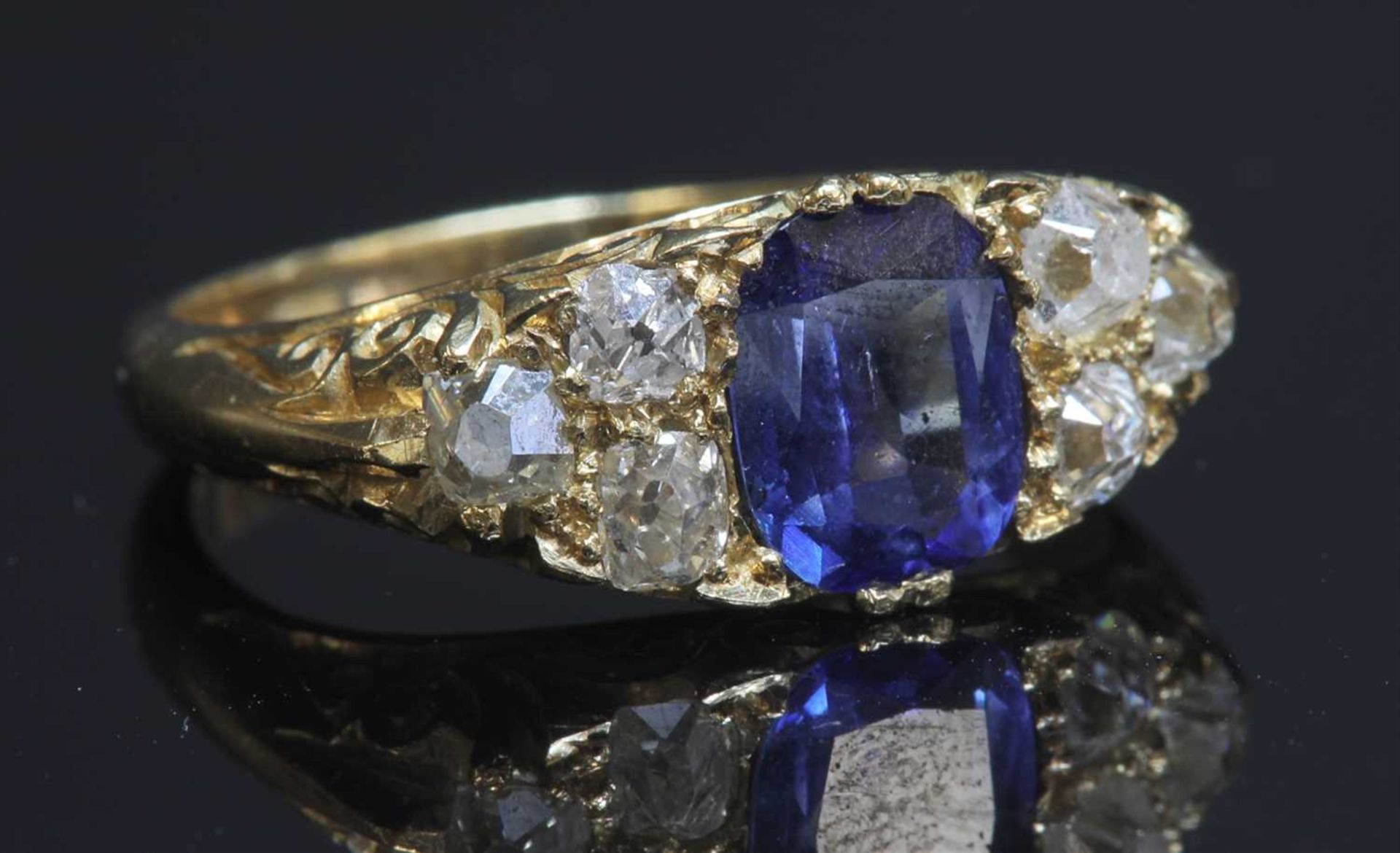 A gold sapphire and diamond carved head ring,