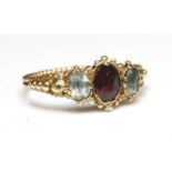 An early Victorian three stone foiled garnet and foiled quartz ring,