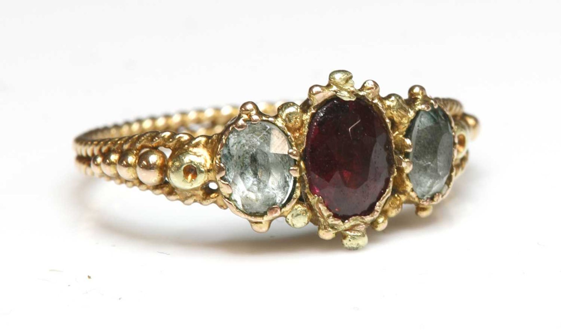 An early Victorian three stone foiled garnet and foiled quartz ring,