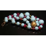 A single row reconstituted turquoise, ruby and gold bead necklace,