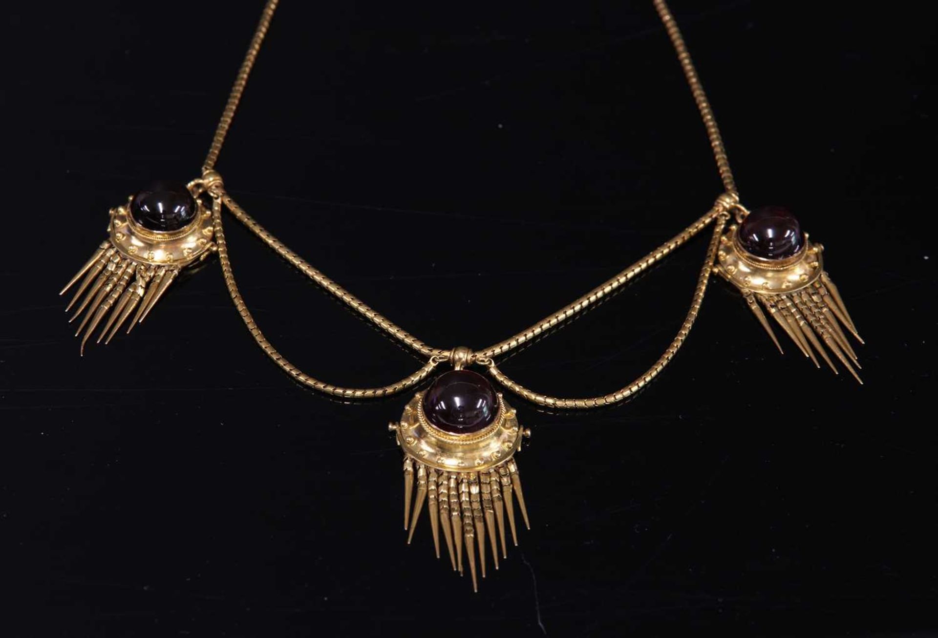 A cased Victorian gold and garnet set Etruscan Revival swag and fringe necklace, c.1860,