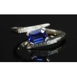 An 18ct white gold sapphire and diamond crossover ring,