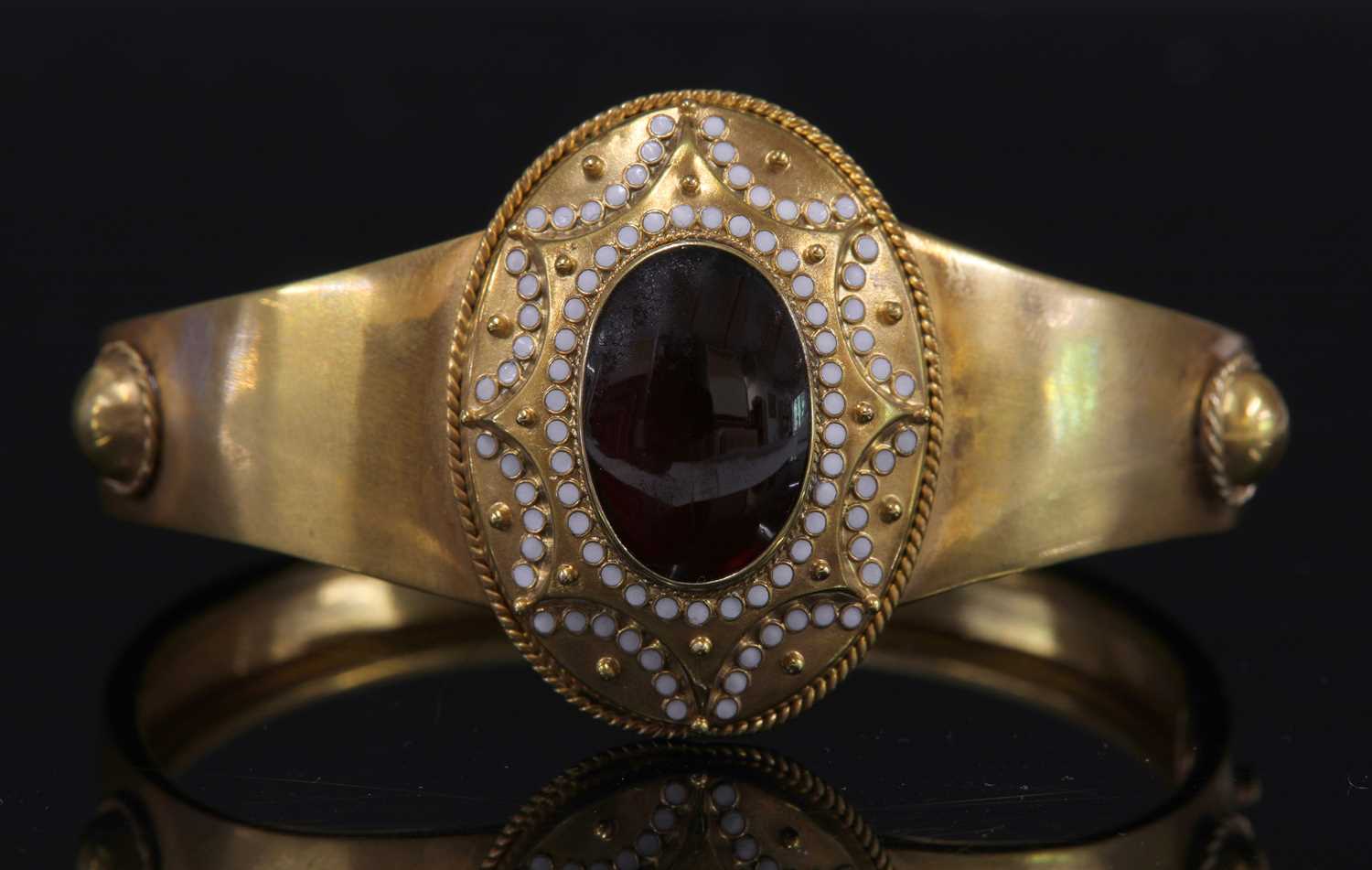 A Victorian gold garnet and enamel hinged bangle, c.1860,