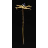 A gold and enamel jockey on horseback stick pin,