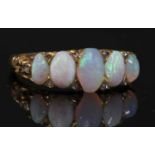 A Victorian gold five stone opal carved head ring,
