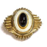 A Victorian Etruscan Revival gold, garnet and enamel, shield form brooch, c.1860,