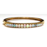 An Edwardian gold opal hinged bangle,