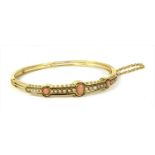 A Victorian gold coral and split pearl hinged bangle,