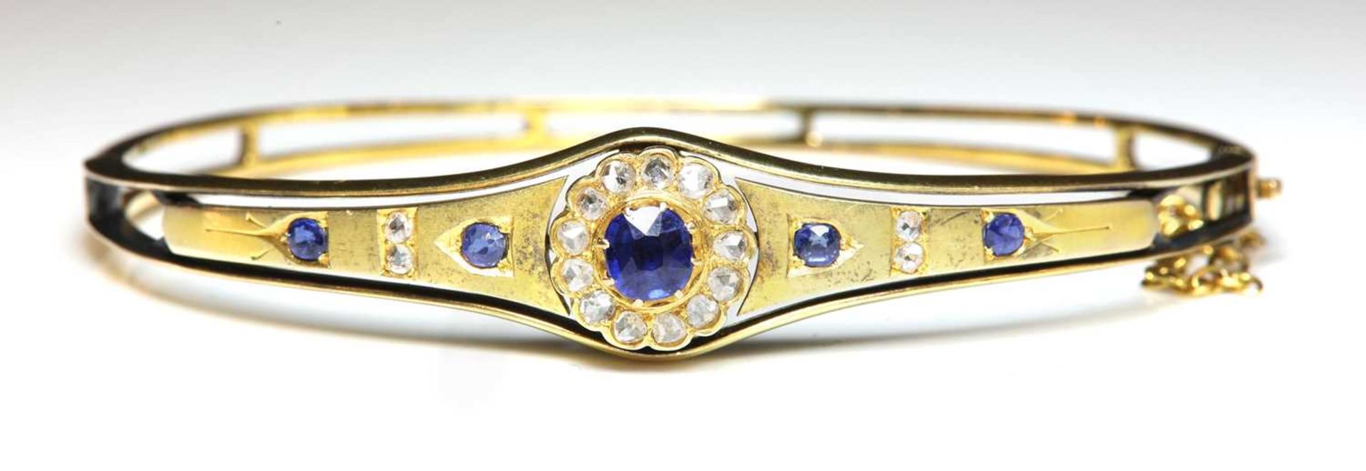 An Edwardian gold sapphire and diamond bangle, c.1900,