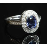 An 18ct white gold sapphire and diamond oval cluster ring,